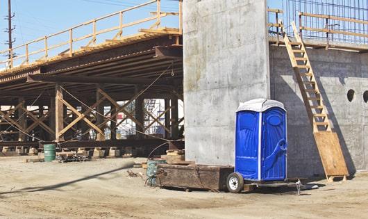 portable toilets stacked at a busy construction site